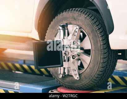 Ausrichtung der Räder Ausrüstung Automechaniker Einbau des Sensors suspension Einstellung Auto setzt auf Reifen für die Diagnose in der Garage Auto Service und Reparatur Stockfoto