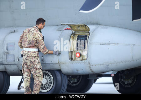 Otopeni, Rumänien - Mai 22, 2019: ein Mechaniker ist die Inspektion von Teilen eines Alenia C-27J Spartan militärischen Frachtflugzeug nach Landung auf einem Flugplatz. Stockfoto