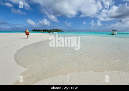 Idyllischer Blick der Touristen zu Fuß auf einem weißen Sandstrand an der türkisfarbenen Lagune von Aitutaki, Cook Inseln, Polynesien Stockfoto