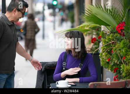 Frau eine Pause in einem Café oder lokalen Cafe in der Stadt und warten, um einen Freund zu treffen. Sie sitzen in einem Straßencafé Restaurant h Stockfoto
