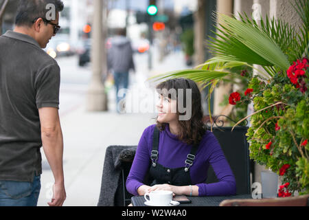 Frau eine Pause in einem Café oder lokalen Cafe in der Stadt und warten, um einen Freund zu treffen. Sie sitzen in einem Straßencafé Restaurant h Stockfoto