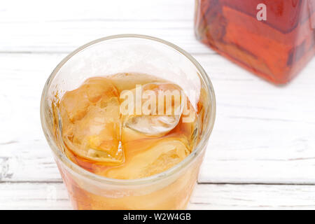 Glas Schale und eine Flasche Whiskey auf weißem Hintergrund Stockfoto