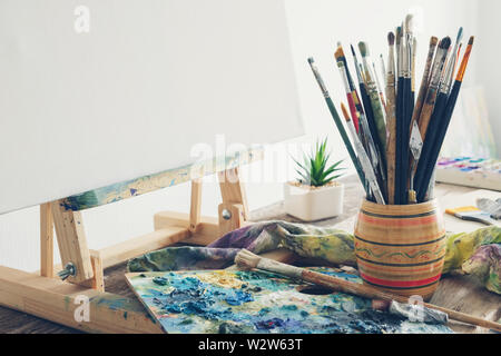 Künstlerische Ausrüstung Studio: Leinwand auf Holz Staffelei, Pinsel und Farben verwendet. Kopieren Sie Platz für Text. Stockfoto