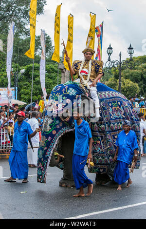 Ein zeremonielles Elefant mit einem buddhistischen Tempel Priester Paraden durch die Straßen von Kandy in Sri Lanka während des Tages Perahera. Stockfoto