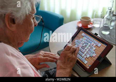 Kassel, Deutschland. 26 Juni, 2019. Gisela Bossecker (95) spielt mit ihrem Tablet Mahyong in der Käthe-Richter-Haus Seniorenheim. In Altersheimen, das Internet war ein Nischendasein. Aber Pflegeheime Umdenken - auch, weil ihre Klientel verändert sich. Quelle: Uwe Zucchi/dpa/Alamy leben Nachrichten Stockfoto