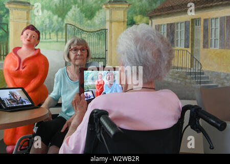 Kassel, Deutschland. 26 Juni, 2019. Gisela Bossecker (R 95) Fotografien Rosemarie Fischer (81) mit ihrem Tablet am Käthe-Richter-Haus Seniorenheim. In Altersheimen, das Internet war ein Nischendasein. Aber Pflegeheime Umdenken - auch, weil ihre Klientel verändert sich. Quelle: Uwe Zucchi/dpa/Alamy leben Nachrichten Stockfoto