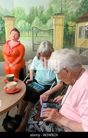 Kassel, Deutschland. 26 Juni, 2019. Rosemarie Fischer (l, 81) und Gisela Bossecker (95) mit ihren Tablet in der Käthe-Richter-Haus Seniorenheim. In Altersheimen, das Internet war ein Nischendasein. Aber Pflegeheime Umdenken - auch, weil ihre Klientel verändert sich. Quelle: Uwe Zucchi/dpa/Alamy leben Nachrichten Stockfoto