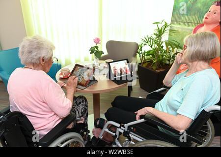 Kassel, Deutschland. 26 Juni, 2019. Gisela Bossecker (l, 95) und Rosemarie Fischer (81) und auf ihren Tablet in der Käthe-Richter-Haus Seniorenheim arbeiten. In Altersheimen, das Internet war ein Nischendasein. Aber Pflegeheime Umdenken - auch, weil ihre Klientel verändert sich. Quelle: Uwe Zucchi/dpa/Alamy leben Nachrichten Stockfoto