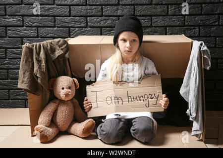 Obdachlose Mädchen Betteln in Innenräumen Stockfoto