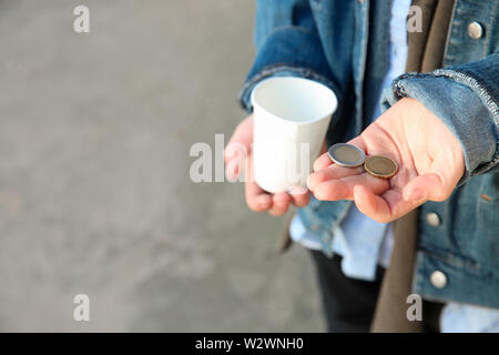 Obdachlose Junge zählen Geld im Freien Stockfoto