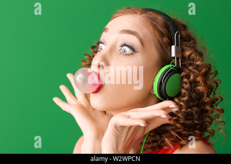 Emotionale junge Frau mit Gummi Musik auf farbigen Hintergrund Stockfoto