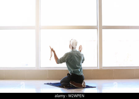 Jungen muslimischen Mann, der betet in Innenräumen Stockfoto