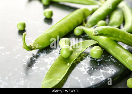 Leckere frische Erbsen auf dunklen Kammer, Nahaufnahme Stockfoto