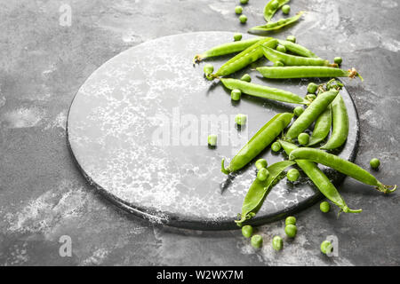 Vorstand mit leckeren frischen Erbsen auf grunge Hintergrund Stockfoto