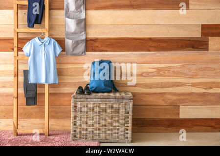 Stilvolle Schuluniform, Rucksack und Schuhe im Zimmer Stockfoto