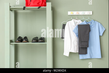 Stilvolle Schuluniform, Rucksack und Schuhe im Zimmer Stockfoto