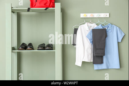 Stilvolle Schuluniform, Rucksack und Schuhe im Zimmer Stockfoto