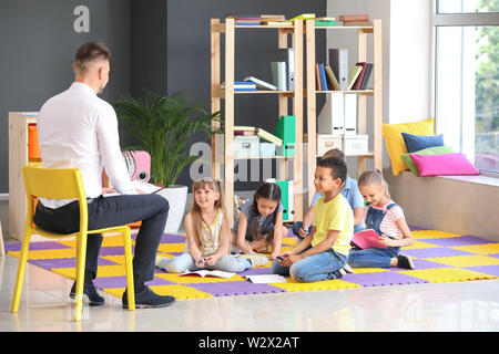 Niedliche Kinder mit dem Lehrer in der Grundschule Stockfoto