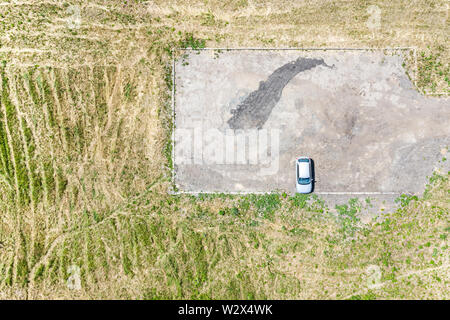 Einzelne weiße Auto auf leere Vorort Parkplatz. Birds Eye View Stockfoto