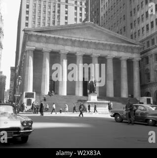 1960, historische, Wall Street, Manhattan, New York und in der säulenhalle Gebäude der Federal Hall, New York City, USA. Ein Denkmal von George Washington befindet sich in der Vorderseite des Gebäudes positioniert. 1842 eröffnet, es diente als einer der US-Treasury Standorte und im Jahr 1939 wurde als Federal Hall Memorial National Historic Site ausgewiesen und im Jahre 1955 wurde ein nationales Denkmal. Stockfoto