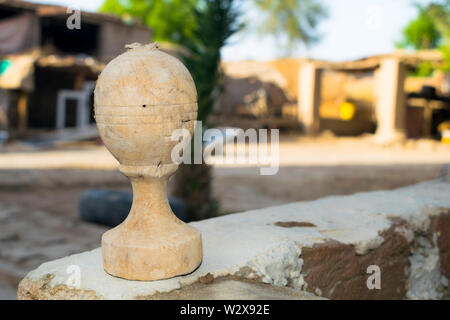 Nahaufnahme eines gebrochenen hölzerne Statue auf einer Wand mit unscharfem Hintergrund. Stockfoto