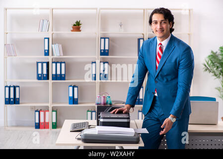 Der junge Arbeitnehmer Kopien beim Kopieren von Maschine Stockfoto