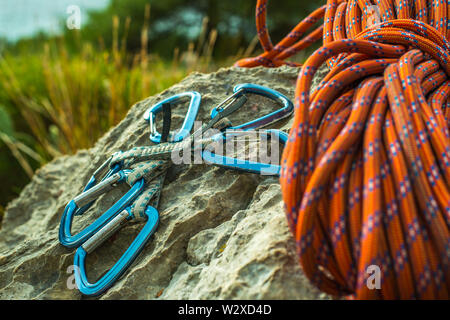 Sicherheitsgeschirr mit Quick-zeichnet, Seil und Kletterausrüstung im Freien auf einem Felsen Stockfoto