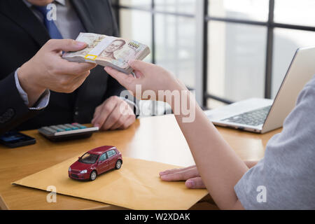 Frauen senden Vertrag und Dokument über Auto Kredit an die Bank senden und empfangen Geld Stockfoto