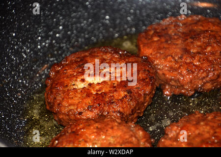 Knusprigen Frikadellen braten in Öl in einer Pfanne detail und Makroaufnahme, bereit, Hackbraten in einem Topf zu essen Stockfoto