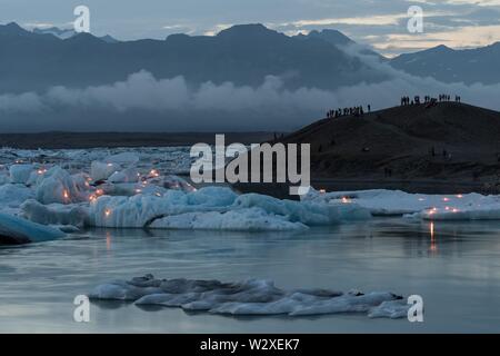 Touristen für das Feuerwerk auf der Gletscherlagune Jokulsarlon, South Island, Island warten Stockfoto