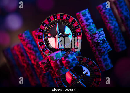 Casino Thema mit verschwommenen Hintergrund. Roulette und Stapel von Chips. Würfel. Stockfoto