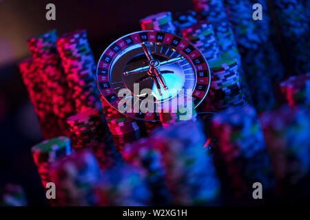 Casino Thema mit verschwommenen Hintergrund. Roulette und Stapel von Chips. Würfel. Stockfoto
