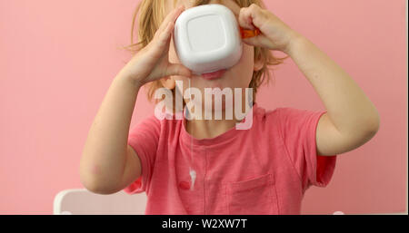 Glückliches Kind trinkt Milch aus einem Becher Stockfoto