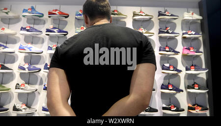 Mann Shopper ist gerade Paar Schuhe im Sport store Stockfoto