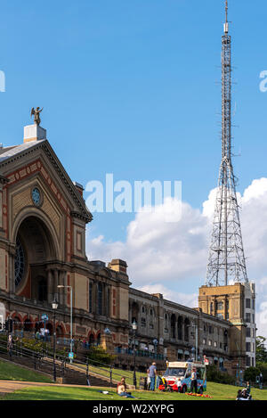 Alexandra Palace Eingang und BBC Television Studios und Antenne mast. Sonnigen Sommertag mit Eis van und Menschen. Denkmalgeschütztes Gebäude Stockfoto