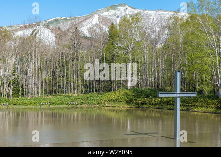 Kreuz auf dem Wasser mit einer umgekehrten Reflexion in einer wunderschönen Natur Wald Berg Hintergrund Stockfoto