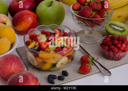 Fruchtsalat mit Beeren, Sommer Nachtisch. Rohe Lebensmittel, Ernährung, Vegetarismus. Auf weissem Hintergrund Stockfoto