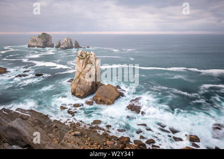 Felsen Urros von liencres und steilen Klippen in kochendem wilde Wellen bei Sonnenuntergang, Costa Quebrada, Kantabrien, Nordspanien Stockfoto