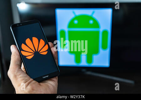 Magdeburg Deutschland - Juni 2019: ein Mann hält ein Android Smartphone Ehren. Auf dem Bildschirm, die huawei Logo vor der Android Logo. Google beschränken Stockfoto