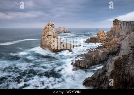 Felsen Urros von liencres und steilen Klippen in kochendem wilde Wellen bei Sonnenuntergang, Costa Quebrada, Kantabrien, Nordspanien Stockfoto