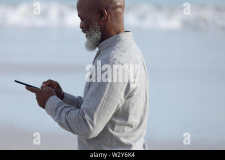 Mann mit einem Handy am Strand Stockfoto