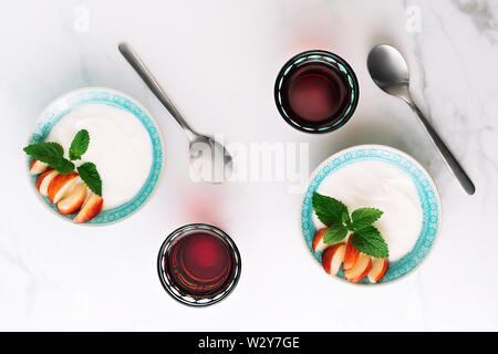 Ansicht von oben gesundes Frühstück der natürlichen griechischer Joghurt, Nektarinen und Saft auf Marmor tisch. Flach. Stockfoto