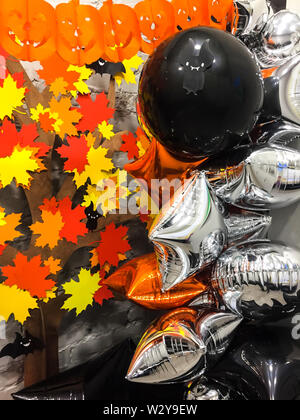 Top viev gelbe Geister Kürbisse mit bunten Blätter im Herbst, Silber und Schwarz Spielzeug, halloween Konzept Stockfoto
