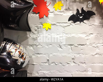 Top viev gelbe Geister Kürbisse mit bunten Blätter im Herbst, Silber und Schwarz Spielzeug, halloween Konzept Stockfoto