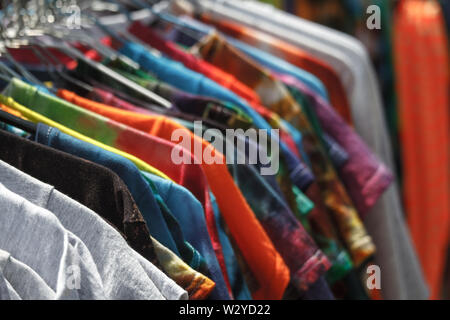 Nahaufnahme des bunten T-Shirts auf Bügeln hängend in der Straße, fair, Secondhand, Recycling Konzept Stockfoto