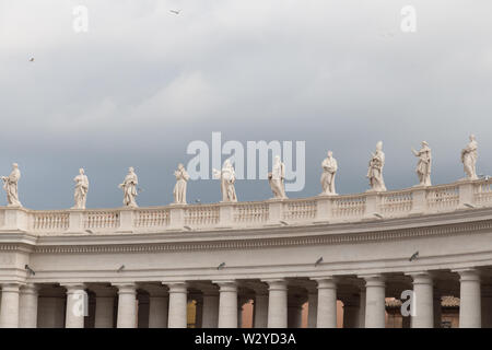 Italien, Vatikanstadt - 18 April 2017: der Blick auf eine Gruppe von Statuen von Peter's Square Kolonnade mit regnerischen Wolken im Hintergrund Am 18. April 2017, Vatica Stockfoto