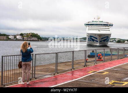 Cobh, Cork, Irland. 11. Juli, 2019. Ein Tourist nimmt eine Snap mit ihr Telefon von der Ankunft des Kreuzfahrtschiff Sea Princess am Australia Day in Cobh, Co Cork, Irland. Stockfoto