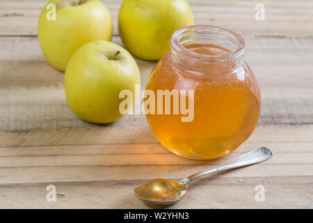 Apfelgelee in einem Glas und Äpfel auf Holz- Hintergrund Stockfoto