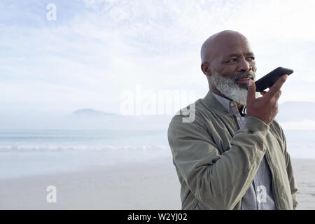 Afrikaner - der Mann am Telefon zu sprechen am Strand Stockfoto
