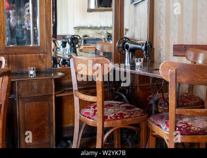 Innenraum der Coffee Shop in Kazimierz, dem historischen jüdischen Viertel von Krakau, Polen, mit Nähmaschinen auf den Tischen. Stockfoto